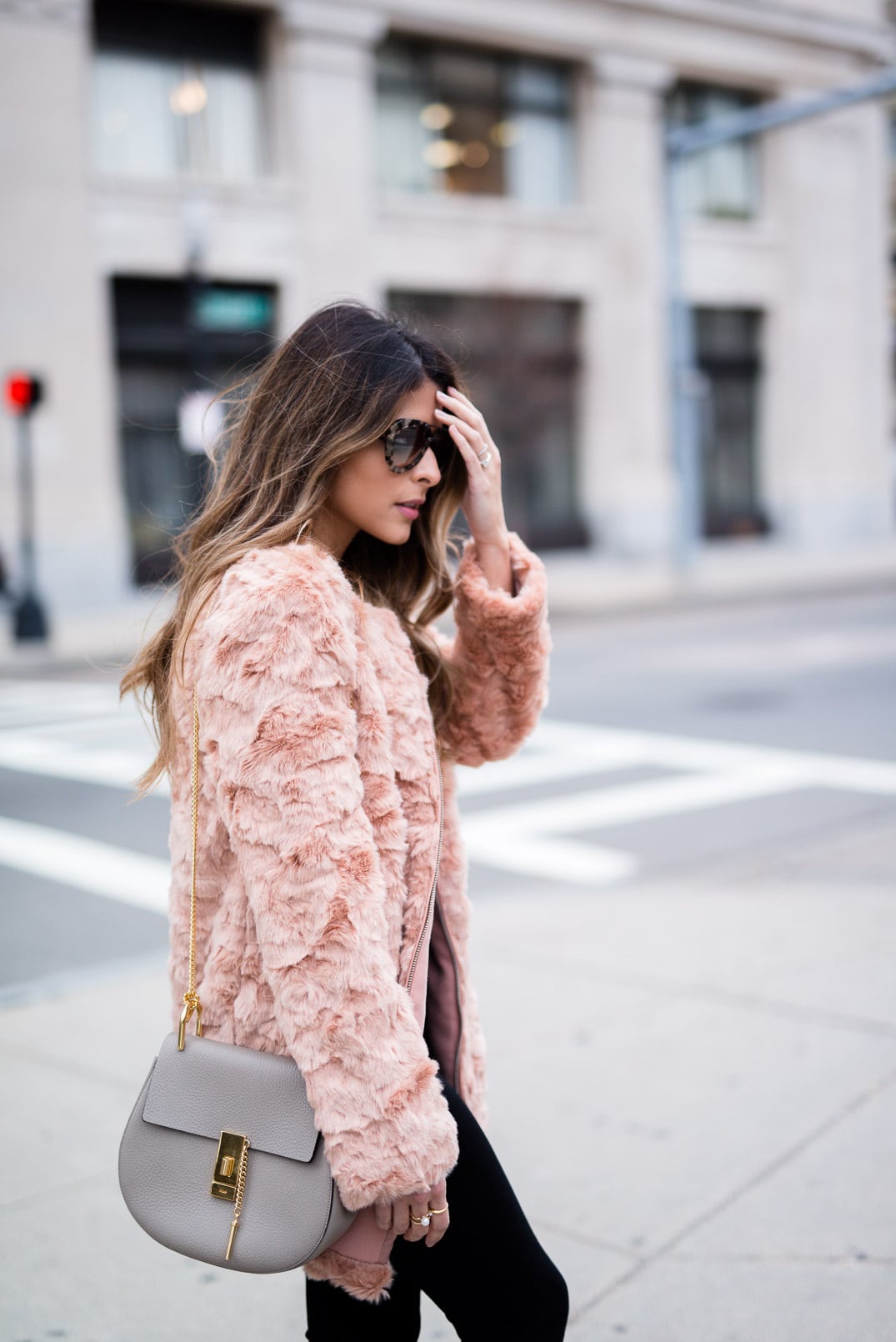 Pam Hetlinger wearing a Forever 21 Faux Fur Jacket, 7 for all Mankind black skinny jeans, delman boots, Chloé Drew Bag and Prada aviators