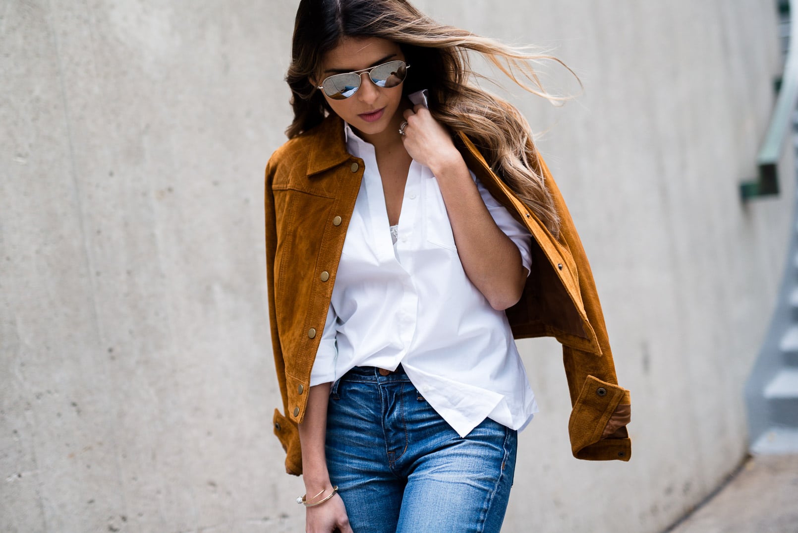 Pam Hetlinger wearing a tan faux suede jacket, nina shoes booties, madewell jeans, white button front shirt, gucci bamboo top handle handbag, free people lace crop top and mirrored aviators