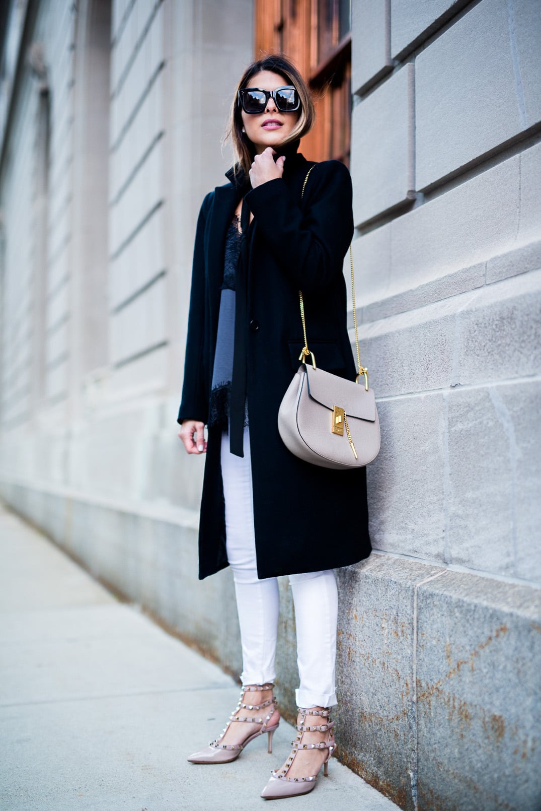 Pam Hetlinger, The Girl From Panama wearing a Mango Lace Top, Zady Black Coat, Valentino Rockstud Sandals, Reiss White jeans and Chloe Drew Bag.