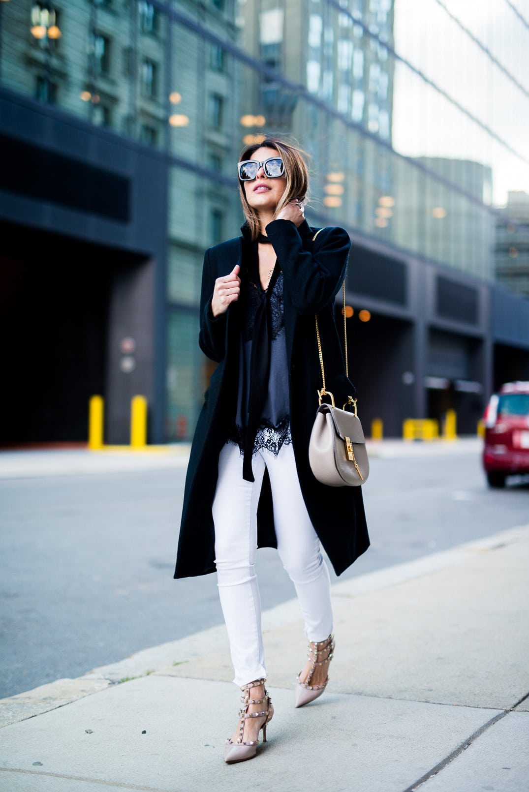 Pam Hetlinger, The Girl From Panama wearing a Mango Lace Top, Zady Black Coat, Valentino Rockstud Sandals, Reiss White jeans and Chloe Drew Bag.