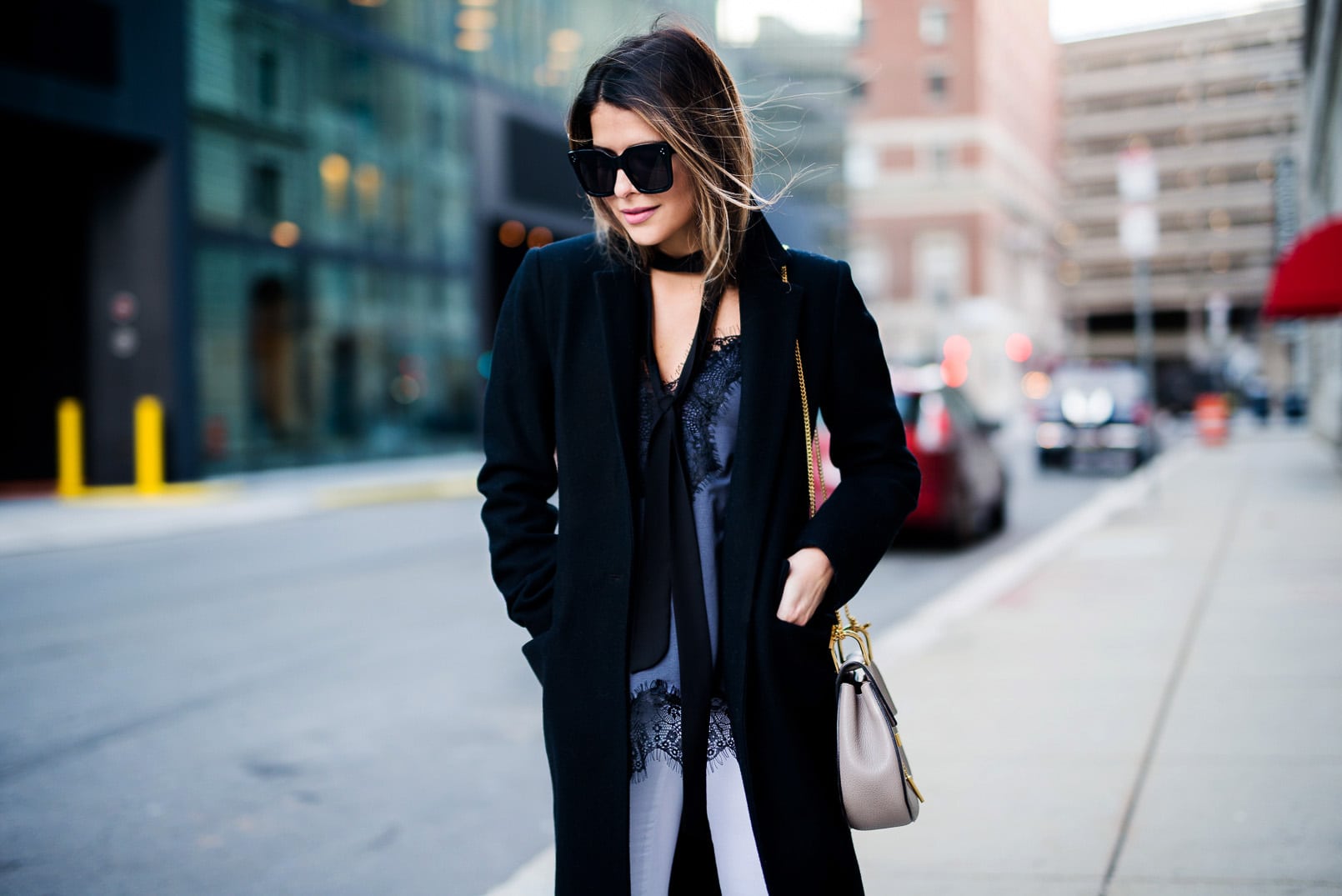 Pam Hetlinger, The Girl From Panama wearing a Mango Lace Top, Zady Black Coat, Valentino Rockstud Sandals, Reiss White jeans and Chloe Drew Bag.