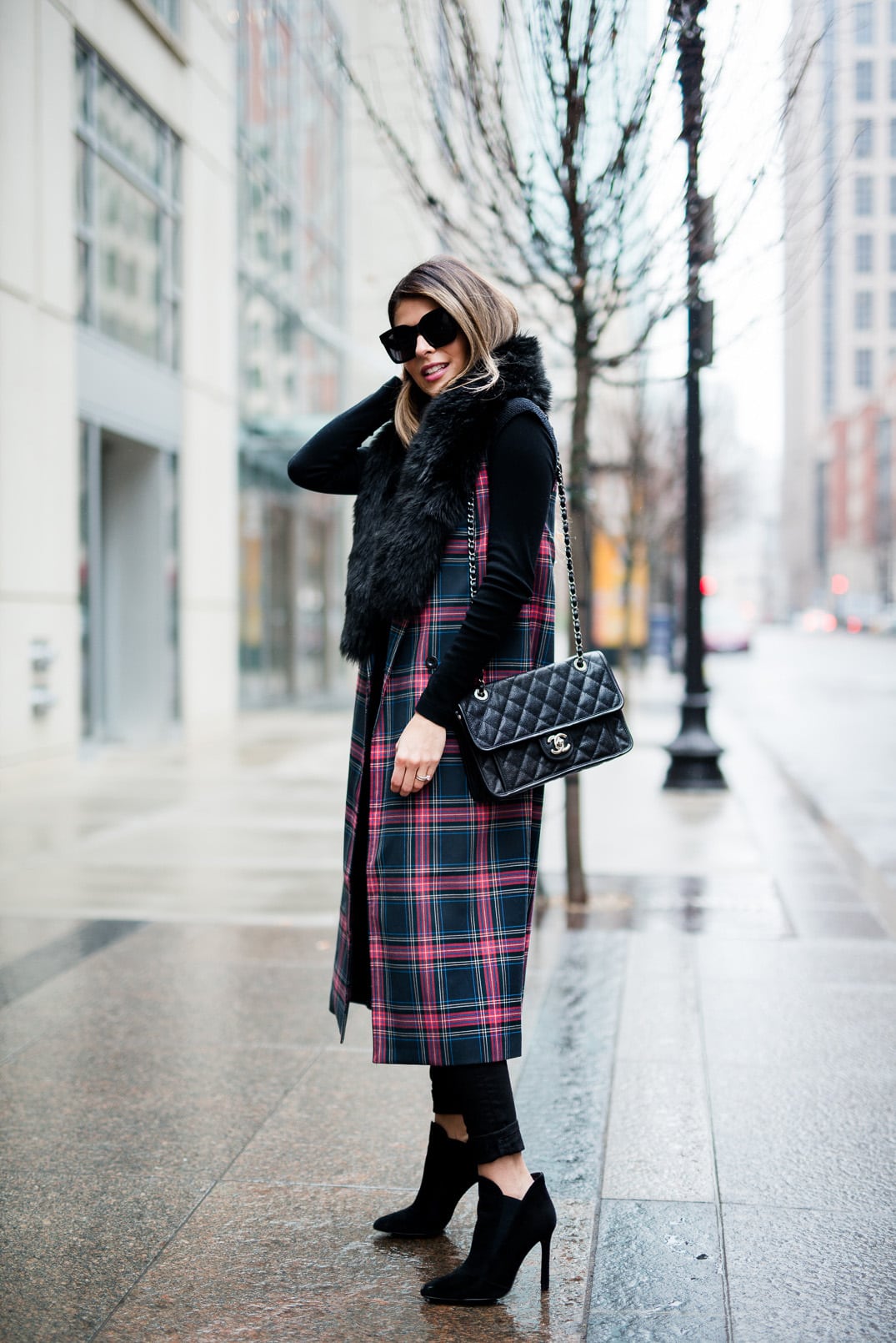 Pam Hetlinger wearing the fifth label tartan plaid vest, ann taylor faux fur stole, black turtleneck sweater, black skinny jeans, and zara black booties