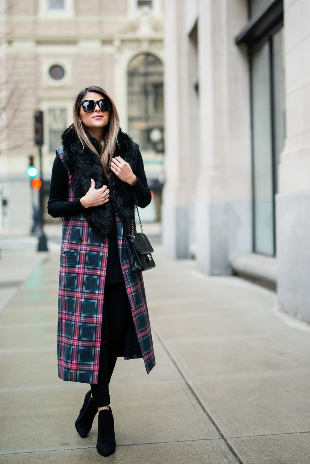 Pam Hetlinger wearing the fifth label tartan plaid vest, ann taylor faux fur stole, black turtleneck sweater, black skinny jeans, and zara black booties