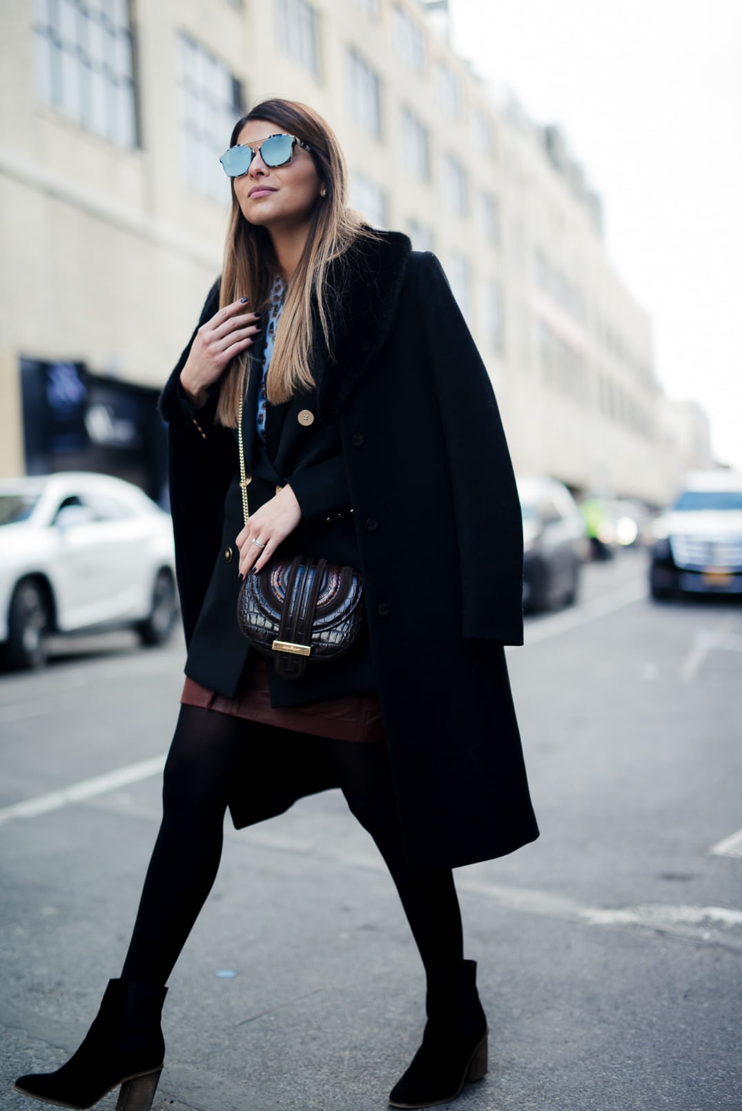 Pam Hetlinger wearing a Reiss printed blouse, black double breasted blazer, black faux fur collar coat, burgundy leather mini skirt and ferragamo bag. New York Fashion Week. 