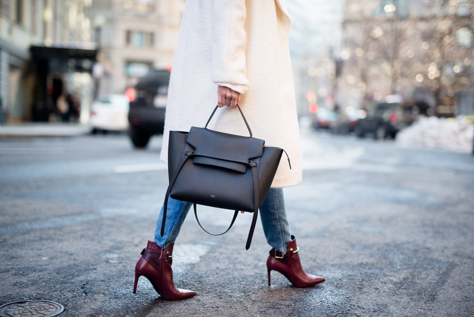 Pam Hetlinger, The Girl From Panama wearing a burgundy hat, asos white oversized coat, 7 for all mankind braided jeans, balenciaga buckle burgundy boots, black turtleneck, How to style a hat in the winter.