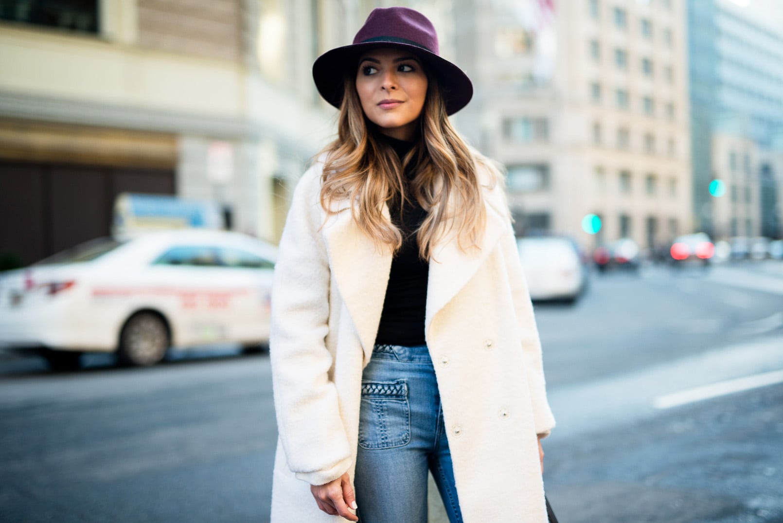 Pam Hetlinger, The Girl From Panama wearing a burgundy hat, asos white oversized coat, 7 for all mankind braided jeans, balenciaga buckle burgundy boots, black turtleneck, How to style a hat in the winter.