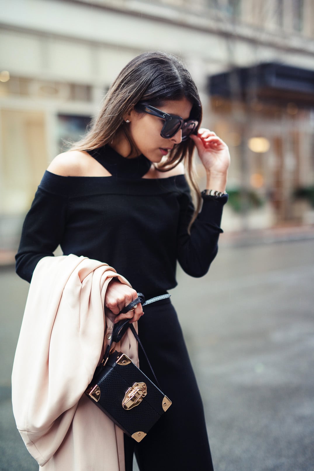 Pam Hetlinger wearing a cold shoulder sweater, black culottes, black booties, and a camel trench coat. Valentine's day outfit idea.