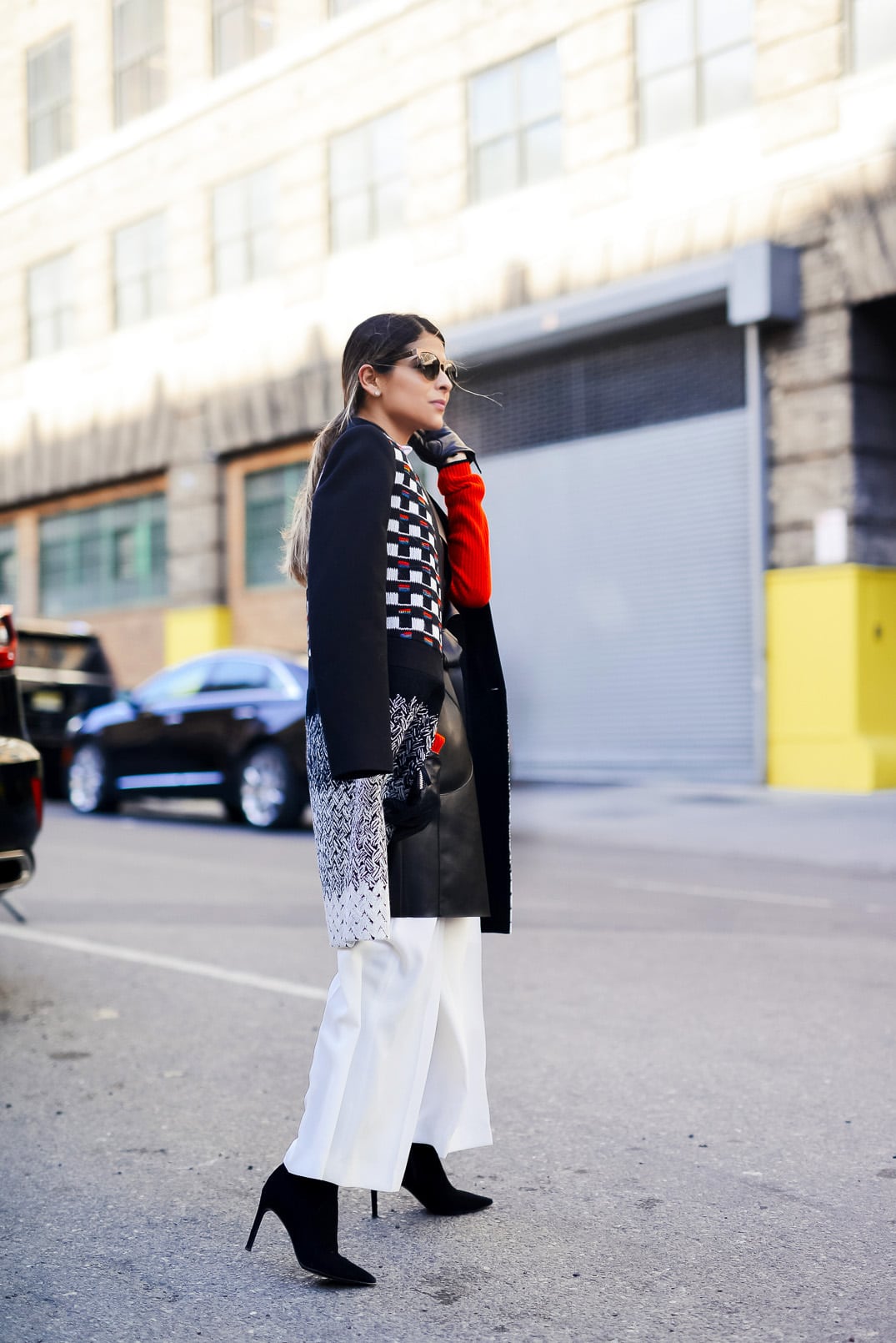 Pam Hetlinger wearing rag and bone red dress, faux-leather vest, white wide leg pants, and black booties