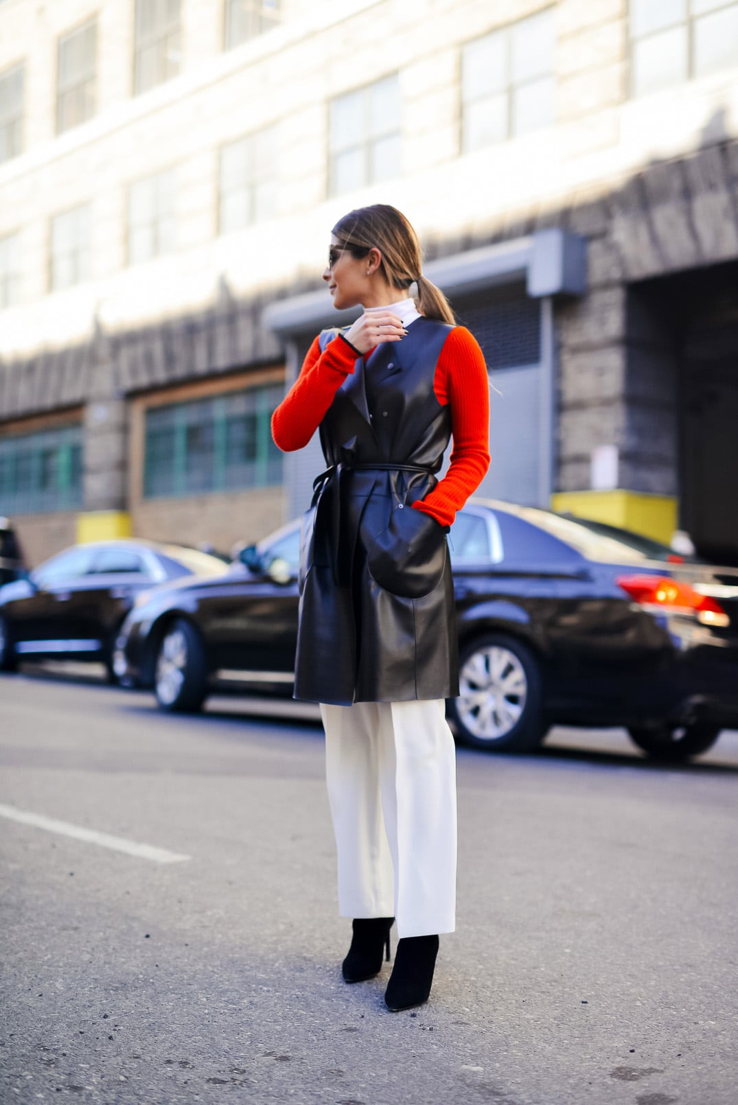 Pam Hetlinger wearing rag and bone red dress, faux-leather vest, white wide leg pants, and black booties