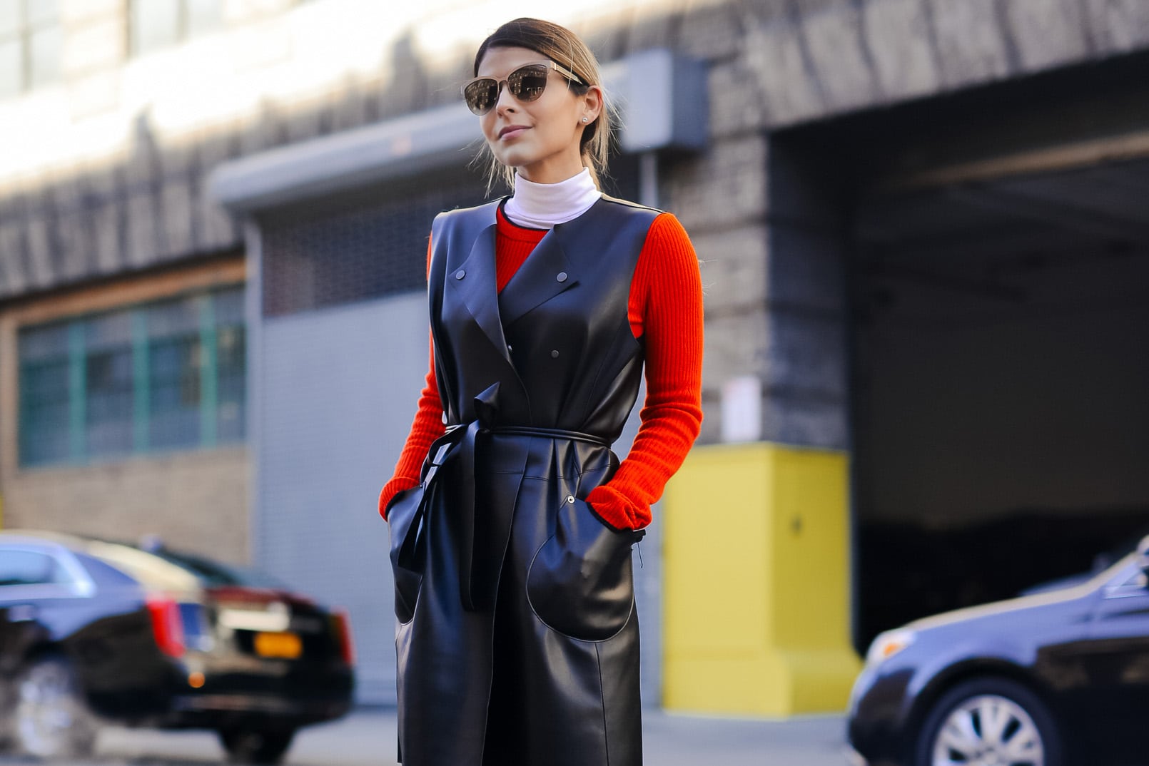 Pam Hetlinger wearing rag and bone red dress, faux-leather vest, white wide leg pants, and black booties