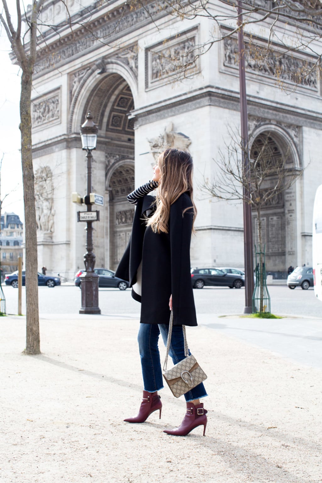 Pam Hetlinger wearing a Kate Spade Jenji Capelet, striped turtleneck, 7 for all Mankind skinny cropped jeans, Gucci Dionysus GG Supreme shoulder bag and balenciage buckle booties. Paris Fashion Week.