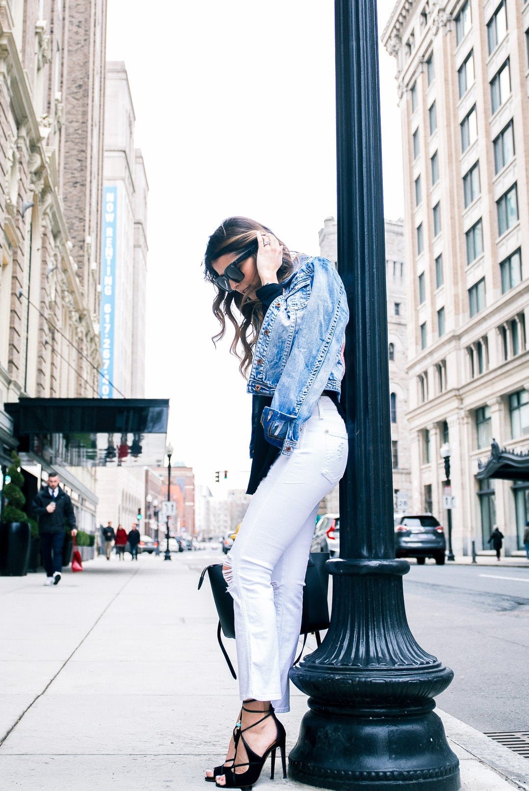 Pam Hetlinger wearing a denim jacket, Aquazzura Poppy Delevingne Hero lace-up suede and leather sandals, cropped white skinny jeans, asos black sweater, and celine belt bag