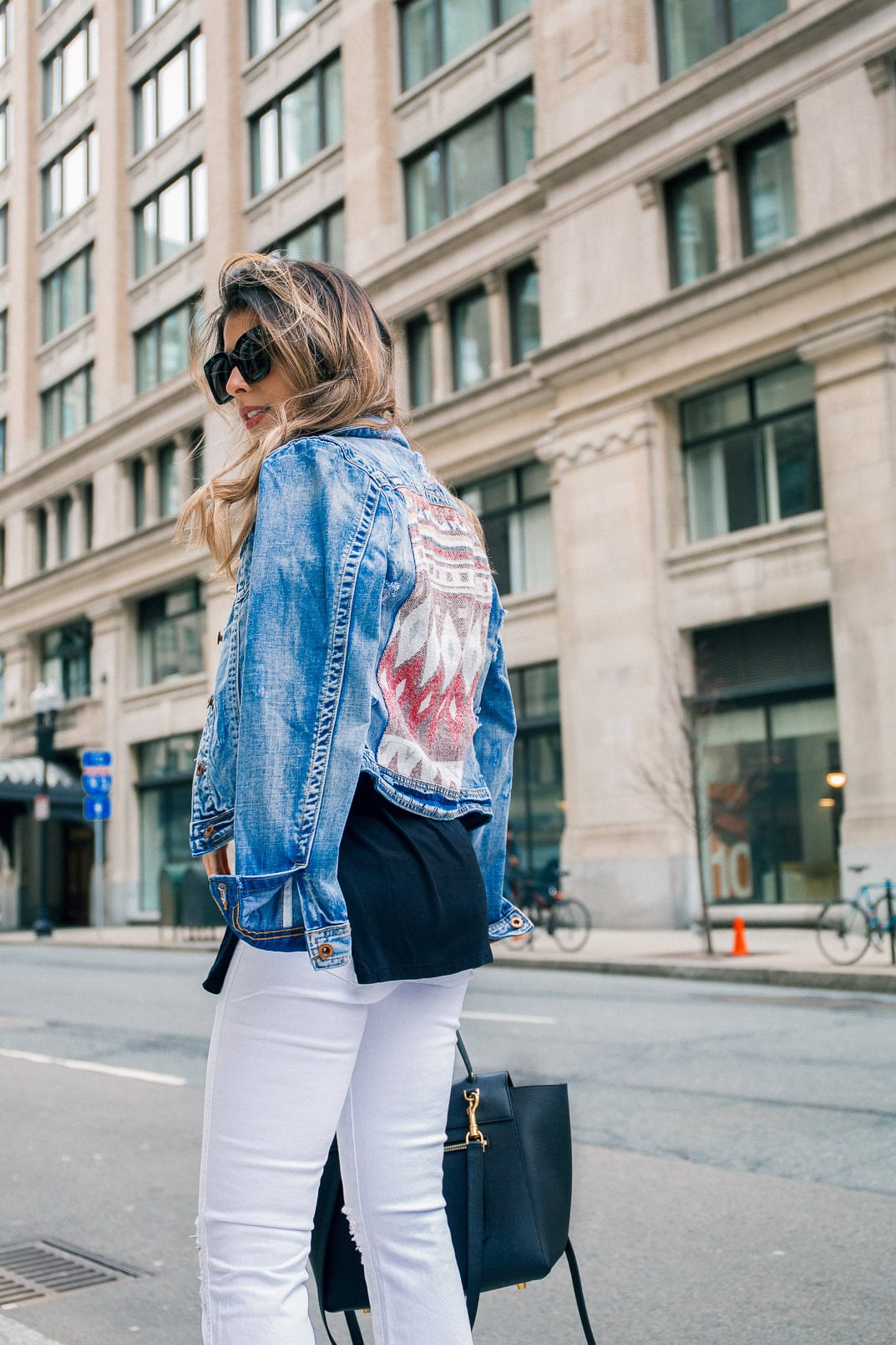 Pam Hetlinger wearing a denim jacket, Aquazzura Poppy Delevingne Hero lace-up suede and leather sandals, cropped white skinny jeans, asos black sweater, and celine belt bag