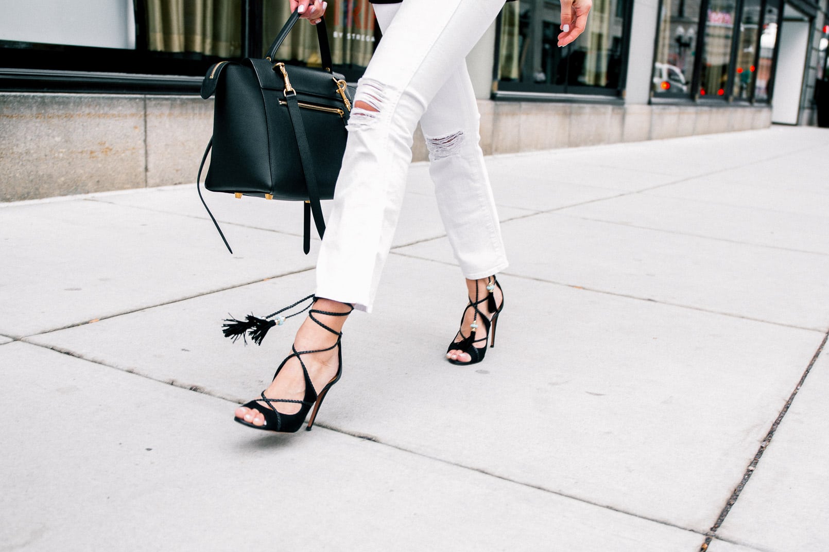 Pam Hetlinger wearing a denim jacket, Aquazzura Poppy Delevingne Hero lace-up suede and leather sandals, cropped white skinny jeans, asos black sweater, and celine belt bag