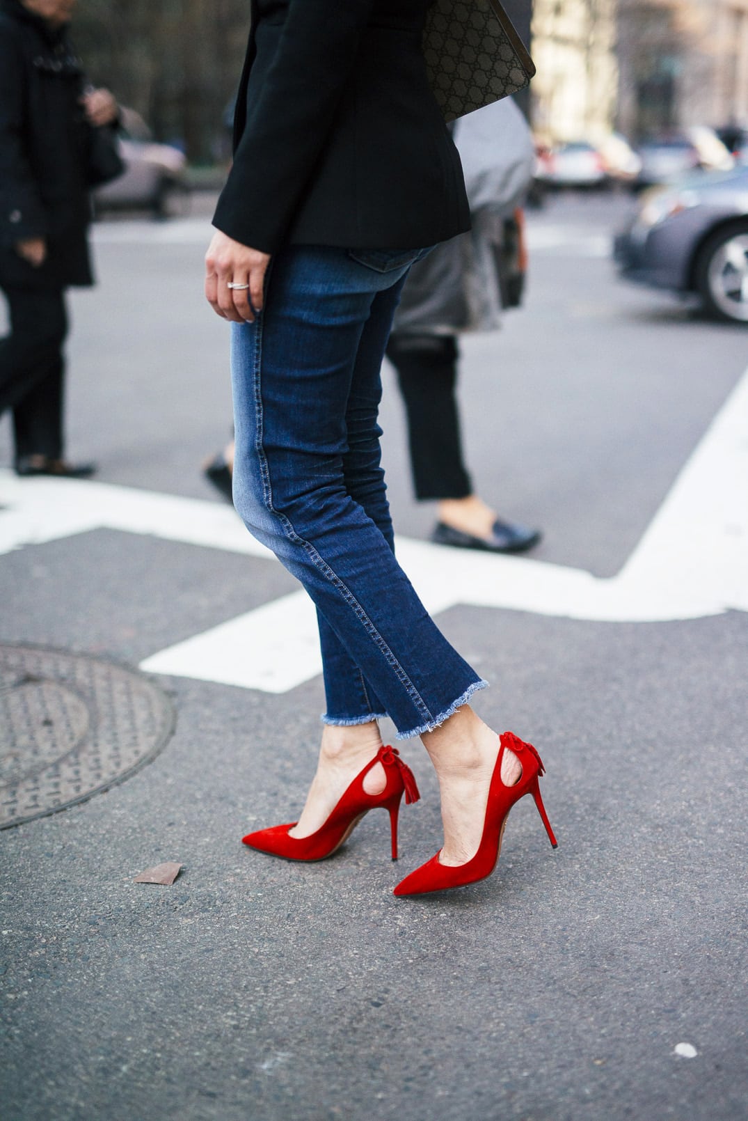 Pam Hetlinger wearing a 7FAM CROPPED HIGH WAIST STRAIGHT WITH RAW HEM, Misha Collection Peplum Top, Gucci Dionysus bag, and Aquazzura Forever Marilyn Pumps in Red.