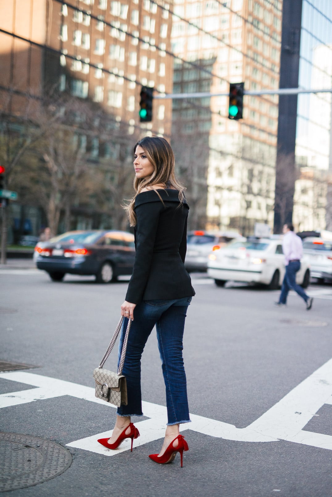 Pam Hetlinger wearing a 7FAM CROPPED HIGH WAIST STRAIGHT WITH RAW HEM, Misha Collection Peplum Top, Gucci Dionysus bag, and Aquazzura Forever Marilyn Pumps in Red.