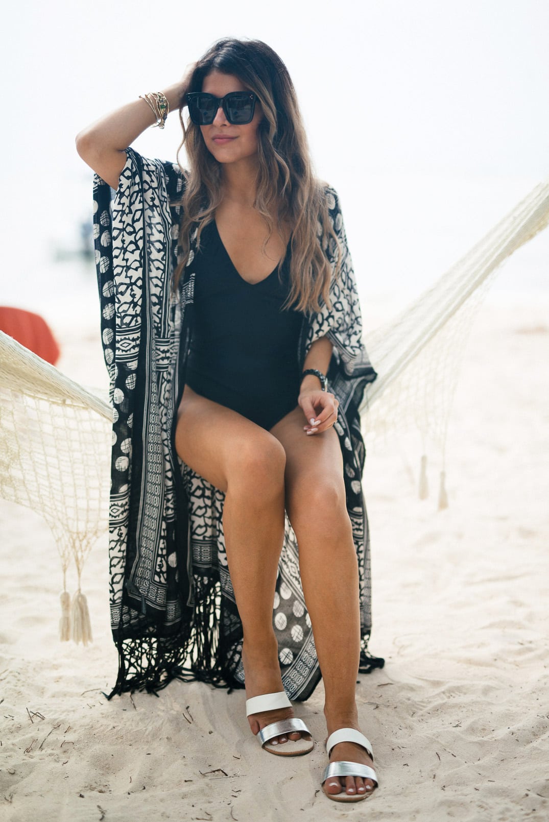 Pam Hetlinger, The Girl From Panama wearing an express black deep v high cut one-piece swimsuit, express mixed black and white print cover-up, two strap slide sandals and a Panama Hat.