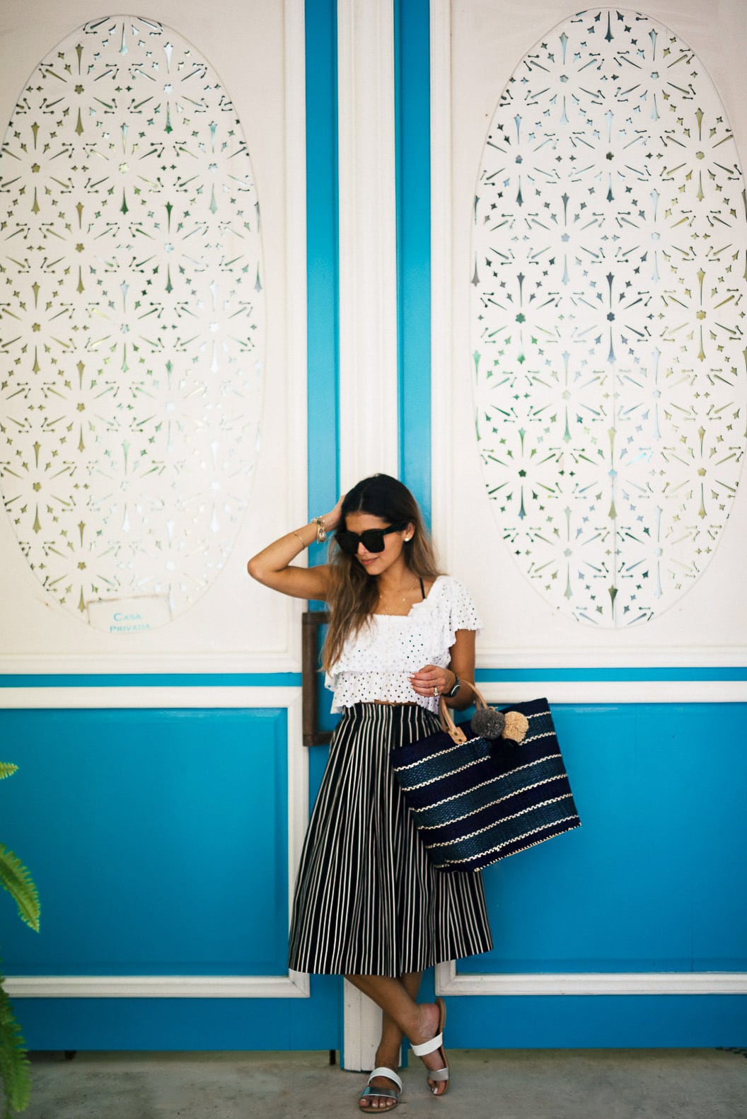 Pam Hetlinger wearing a crochet crop top, good night macaroon White Eyelet Boat Neck Dress, gaia pompom bag, mar y sol capri beach pom pom tote, j.crew striped skirt, and express two strap sandals, Playa del Carmen.