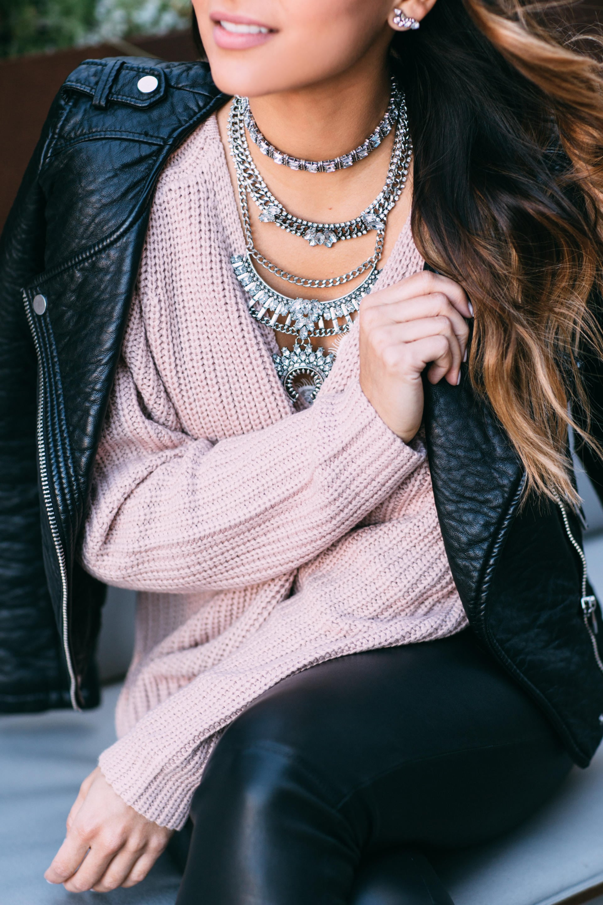 Pam Hetlinger wearing a pink sweater, leather leggings, leather jackets, booties, statement necklace | The Girl From Panama