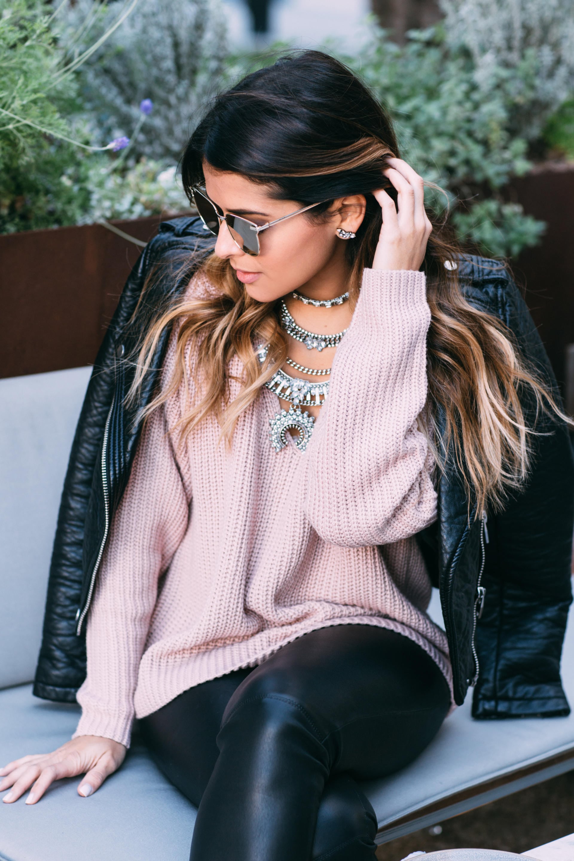 Pam Hetlinger wearing a pink sweater, leather leggings, leather jackets, booties, statement necklace | The Girl From Panama