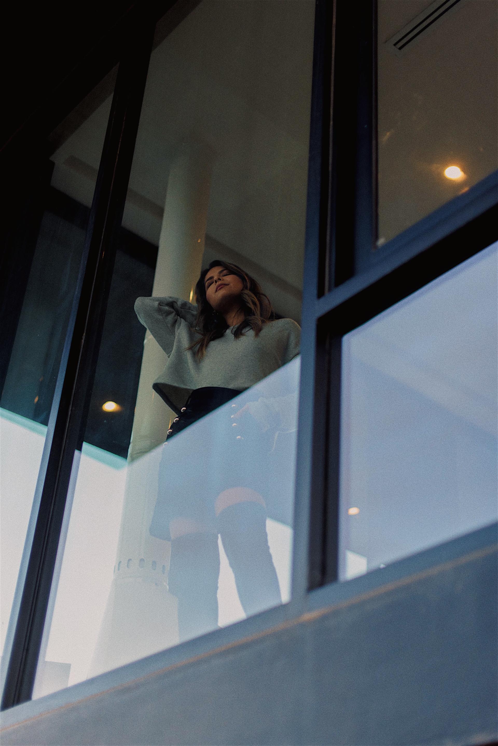 Pam Hetlinger wearing a grey sweater, black skirt and over the knee boots