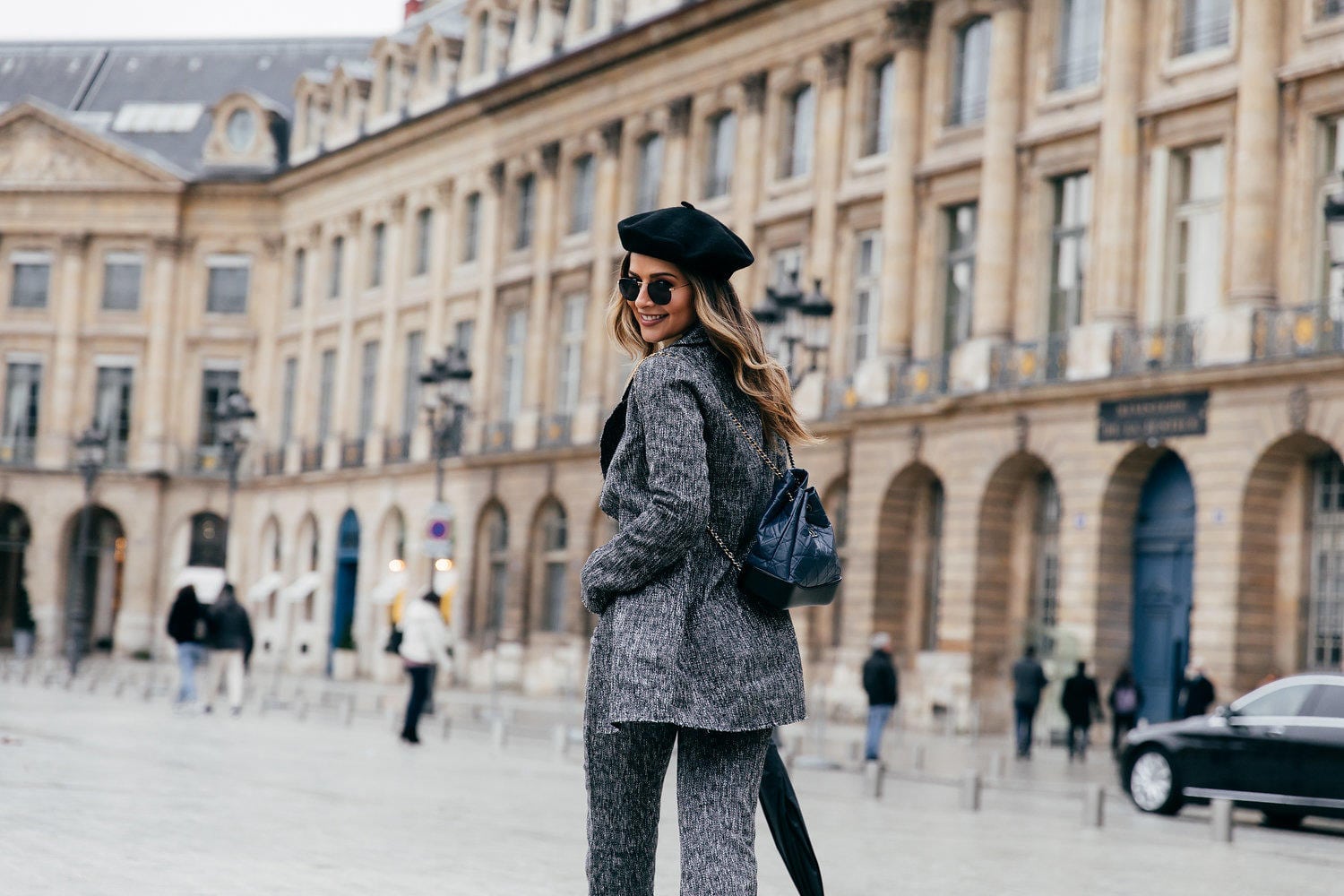 TheGirlFromPanama.com | Paris Travel Guide in the Winter | Pam Hetlinger at Place Vendome wearing a beret hat and a grey jacket in Paris France