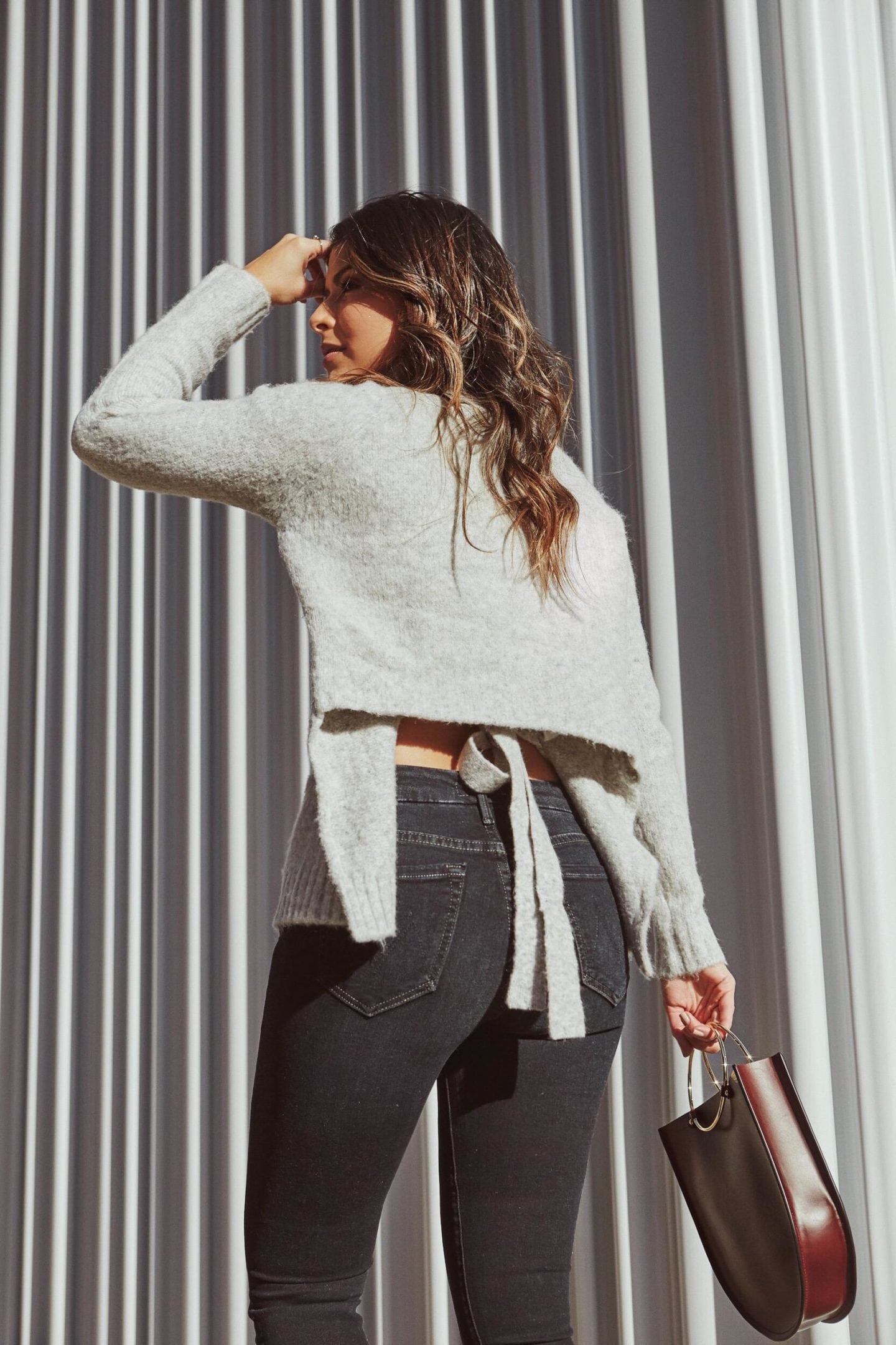 How to Freshen Up Your Winter Wardrobe - Gray Knit Sweater with Tie Back Detailing and Dark Denim | Thegirlfrompanama.com