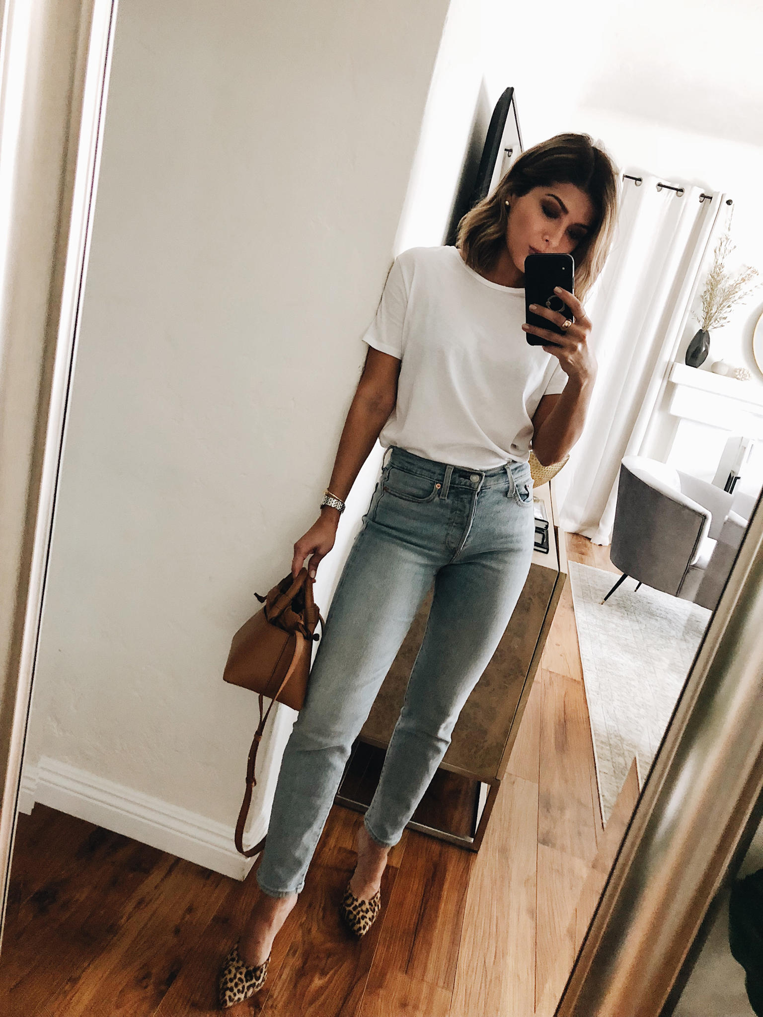 Stylish pretty girl in high-waisted jeans, white T-shirt and